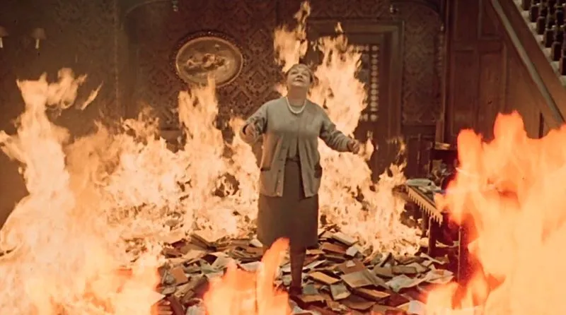 The lady who possessed the secrete library is in the fire being burned alive with her books in Fahrenheit 451 (1966) film.